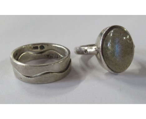 A silver coloured stacking ring, in two sections, together with a stone set ring