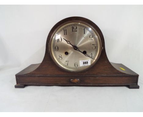 A oak cased mantel clock striking the hour and half hour, German movement marked Haller AG, Arabic numerals on a silvered dia