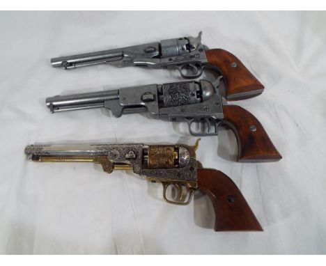 Three replica percussion pistols two in the form of Colt navy pistols and one in the form of a Colt dragoon pistol