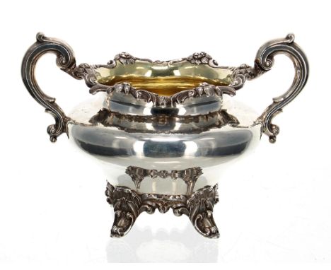 Victorian silver twin-handled sucrier, with C scroll handles and a cast foliate rim, the interior gilt, raised on four scroll