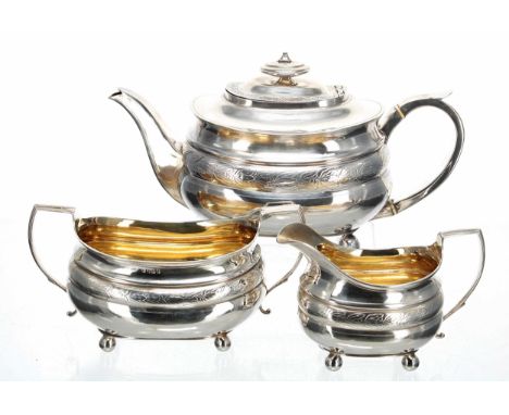 George III silver three piece tea set, each piece decorated with a foliate engraved band and raised on four ball feet, the ju