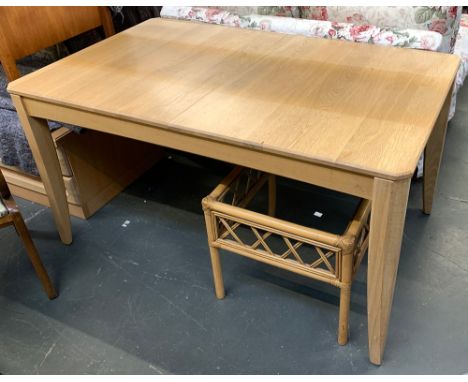 An Ercol light oak dining table 