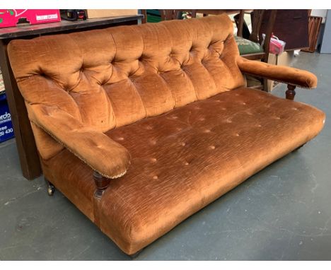 A late 19th/early 20th century low button back two seater settee, on turned legs and brass casters, 140cmW 