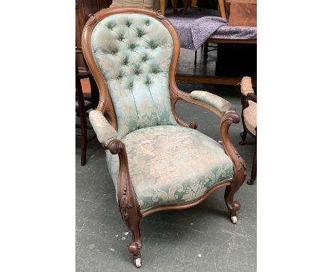A 19th century button back salon chair, serpentine seat, carved rail and arm supports, on carved cabriole legs with ceramic c