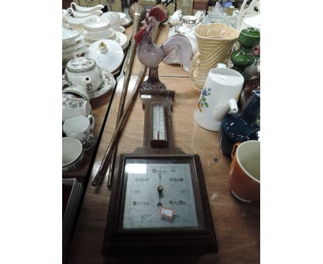 A vintage barometer and figure of a glass cockral