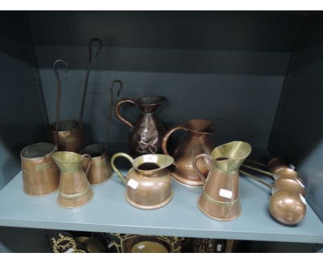 A selection of copper wares including graduated scoop set and cider ladle 