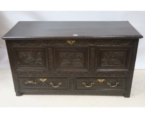 A GEORGIAN CARVED OAK COFFER, the rectangular top with moulded rim above the foliate carved panelled front with spiral carved