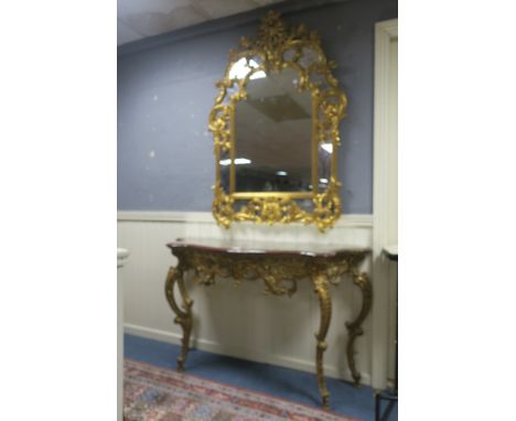 A CONTINENTAL STYLE GILT CONSOLE TABLE AND MIRROR, the scrolling foliate compartmented mirror headed by a pierced cartouche a