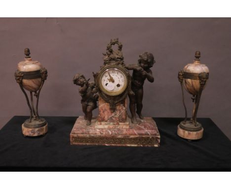 A 19TH CENTURY CONTINENTAL CLOCK GARNITURE, the morrow mounted clock with white enamel dial flanked by a gilt brass musical t