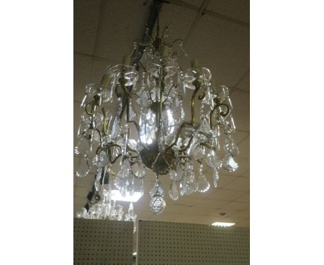 A CONTINENTAL GILT BRASS AND CUT GLASS TWELVE LIGHT CHANDELIER, the tubular frames with diamond cut casings issuing scrolled 