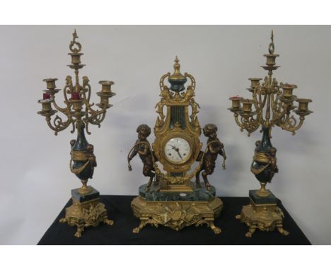 A CONTINENTAL GILT BRASS AND GREEN MARBLE THREE PIECE CLOCK GARNITURE, the white enamel dial with black Roman numerals housed