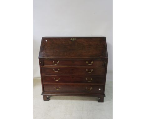 A GEORGIAN MAHOGANY BUREAU, the rectangular top above a fall front revealing a fitted interior the base with four long gradua