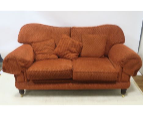 A CONTEMPORARY SOFA of rectangular form the close upholstered frame with scrolled arms fitted with loose back and seat cushio