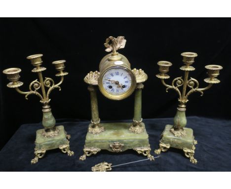 A CONTINENTAL GREEN ONYX AND GILT BRASS MOUNTED CLOCK GARNITURE, the circular white enamelled dial blue Roman numerals headed