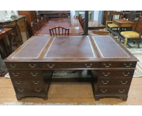 A 19TH CENTURY GEORGIAN STYLE MAHOGANY PARTNERS DESK, the compartmented brown leather tooled top with moulded rim above a lon