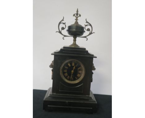 A VICTORIAN BLACK MARBLE MANTLE CLOCK of rectangular form the stepped top headed by a brass mounted classical urn above the b