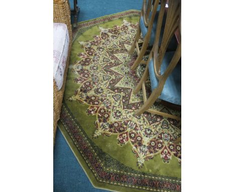 A WOOL RUG, the light green beige and green ground with central panel within a conforming border.