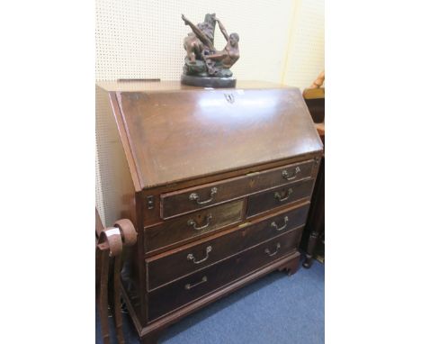 A GEORGIAN MAHOGANY CROSSBANDED BUREAU, the hinged lid containing pigeon holes and drawers above one long two short and two l