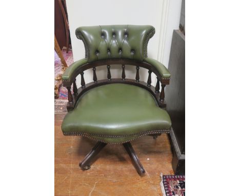 A GREEN LEATHER UPHOLSTERED TUB SHAPED OFFICE CHAIR,  the button upholstered raised back and arms above column supports serpe