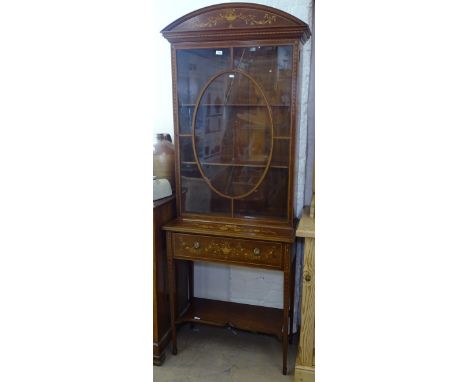 A Sheraton style Edwardian mahogany bookcase, having a lattice-glazed panelled door, with single frieze drawer and shelf unde