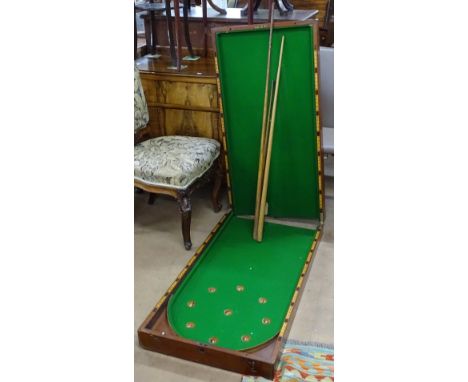 A Victorian mahogany folding bagatelle board, complete with cues and balls 