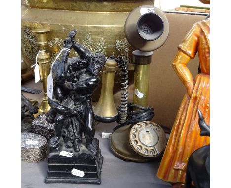 A black painted resin sculpture, depicting intimate wrestlers, and a Vintage brass candlestick telephone, converted to modern