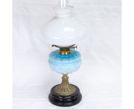 An Edwardian brass oil lamp, with blue milk-glass floral font and polished black ceramic base, overall height 35cm 