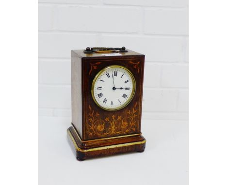 A French rosewood and inlaid mantle clock, the enamel dial with Roman numerals with a brass carry handle to top on four woode