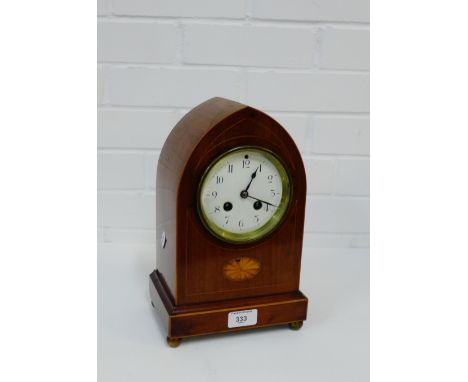 A mahogany and satin inlaid mantle clock, the enamel dial with Arabic numerals and an inlaid paterae raised on four brass bun