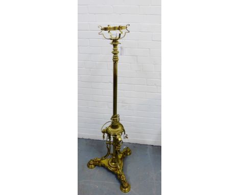 A brass standard lamp on tripod base with hairy paw feet, 135cm high