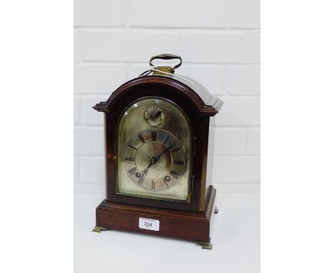 A 19th century mahogany cased bracket clock, the arched top over a silvered dial with Roman numerals to the chapter ring belo