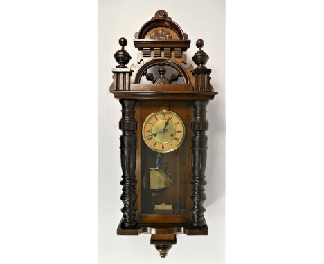 A Vienna style wall clock, carved mahogany case with brass enamelled dial, pendulum &amp; weights. 85cm long. 