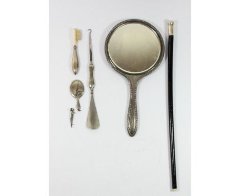 A silver hand mirror, Birmingham 1922, a miniature mirror, Birmingham 1916a silver mounted toothbrush, combined button hook/s