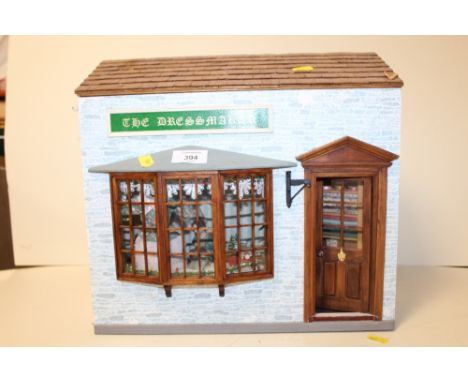 A VINTAGE DOLLS DRESSMAKER SHOP MODEL H - 33CM W- 37CM 