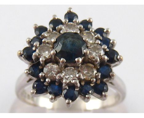 An 18 carat white gold sapphire and diamond cluster ring, size O, 5.9 gms.
