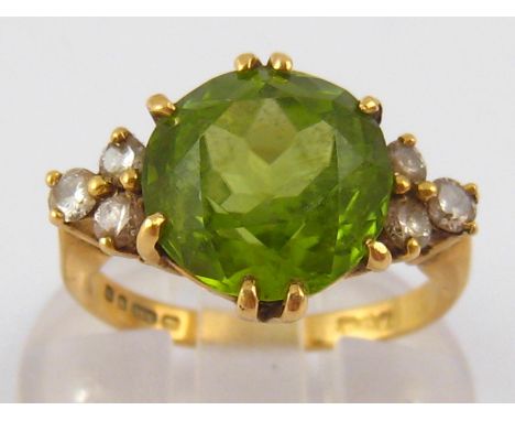 An 18 carat gold peridot and diamond ring, peridot approx 11mm diameter, ring size G, 5.5 gms.