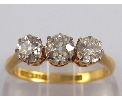 An 18 carat gold and platinum three stone diamond ring, the central old brilliant cut diamond of fine colour measuring approx