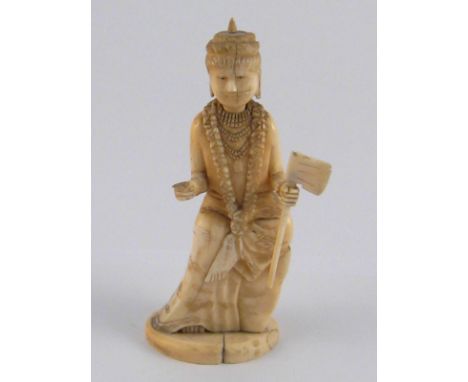 A carved ivory figure of a deity wearing a garland, seated on a rock and carrying a staff and a short hand axe. ht.15cm, circ