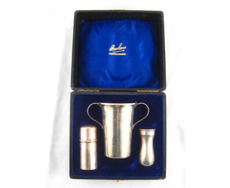 A silver shaving set comprising a shaving brush in reversible holder, a shaving stick case and a two handled mug, by William 