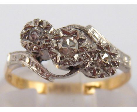 A yellow and white metal (tests 18 carat gold and platinum) three stone diamond ring, size K, 2.2 gms.
