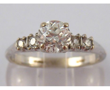 A white metal (tests 18ct gold) five stone diamond ring,  the principal old cut brilliant diamond of good colour and clarity 