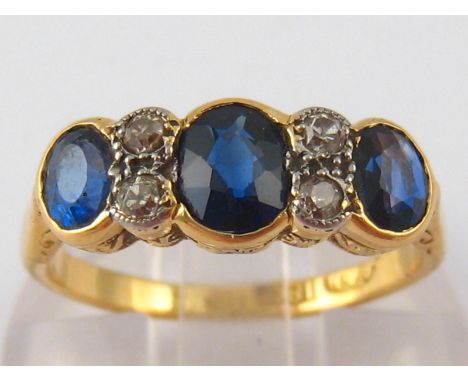 An 18 carat gold sapphire and diamond ring, with platinum settings, largest sapphire approx 6 x 4 mm, ring size J, 3.4 gms.
