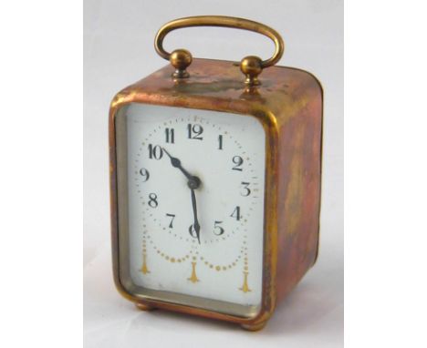 A brass cased bedside alarm clock, circa 1920, with gilt decorated enamel dial, hidden  alarm setting dial at rear. Ht. 10cm.