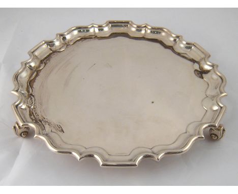 A silver waiter with chippendale rim on leaf capped scroll feet by Thomas Bradbury & Sons, Sheffield, 1919. 31cm. diameter, w