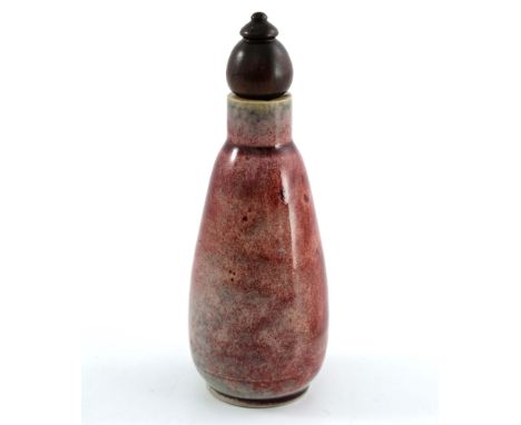 Ruskin Pottery, a High Fired scent bottle, circa 1920, rounded conical form, with screw thread and wooden stopper, ox blood a