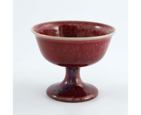 Ruskin Pottery, a High Fired Melba cup, circa 1915, pedestal bowl form with everted rim, ox blood with purple and green speck