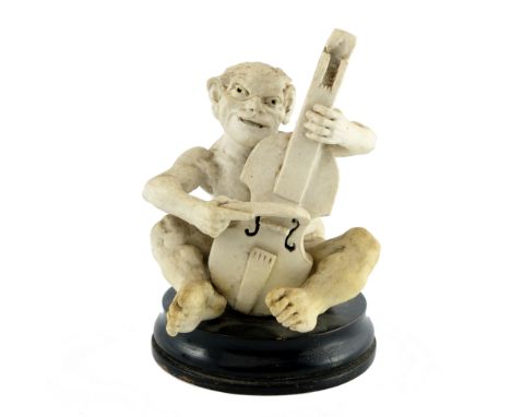 Robert Wallace Martin for Martin Brothers, a stoneware musical imp figure, 1893, modelled playing the cello, white bisque, on