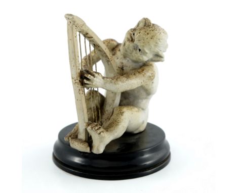 Robert Wallace Martin for Martin Brothers, a stoneware musical imp figure, circa 1893, modelled playing the harp, speckled cr