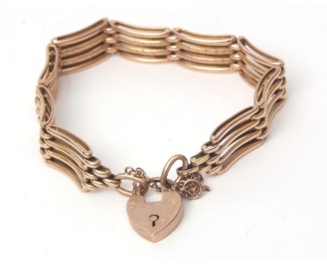 Yellow metal four-bar gate bracelet comprising nine shaped links, the two central bars engraved and chased detail, heart padl