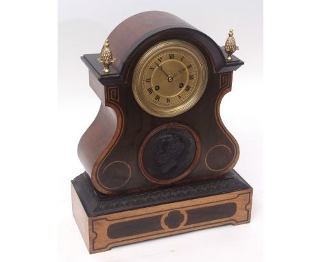 Mid-19th century walnut and ebonised stencilled mantel clock, the arched case with overhanging cornice surmounted by pineappl